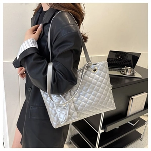 Detail of silver quilted tote bag with metallic finish and small matching purse