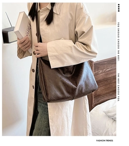 Detail of dark brown tote bag with retro litchi texture and elegant stitching
