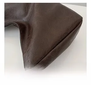 Close-up of deep brown leather texture and soft pebbled grain on a tote bag