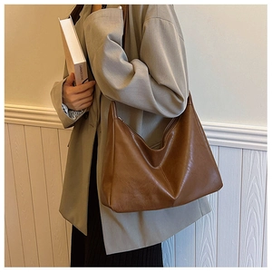 Deep brown oil-wax faux leather hobo bag styled with a professional grey-green suit