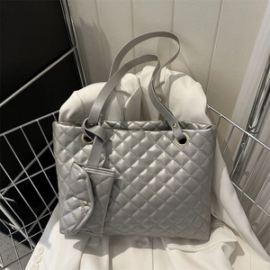 Silver quilted tote bag with diamond pattern and matching coin purse in a metal basket