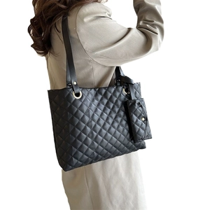 Quilted black leather tote bag with matching mini pouch and shoulder straps for women