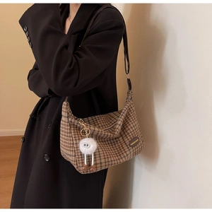Plaid wool tote bag detail featuring vintage brown check fabric and plush monster charm