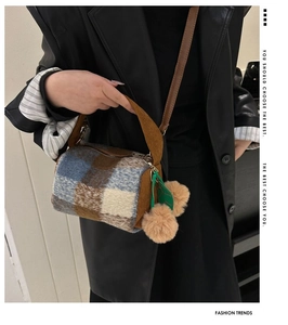 Detail of wool plaid barrel bag with corduroy handles and cute double pompom charms