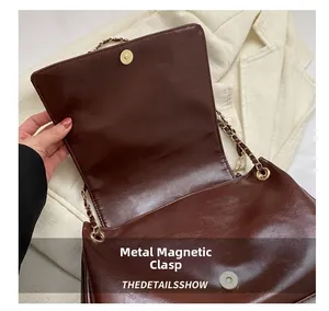 Detailoverzicht van de bruine leren tas met een veilige metalen magneetsluiting