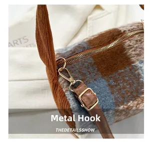 Close-up of durable metal hook hardware on a plaid wool crossbody pillow bag