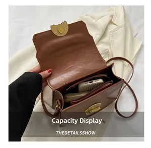 Interior capacity display of brown vintage shoulder bag with phone and wallet inside