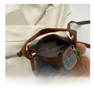 Detail showing internal capacity of plaid plush handbag with phone and metal zipper