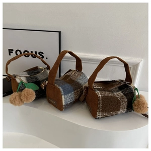 Detailed view of three plaid faux fur mini tote bags with corduroy handles and pompom charms