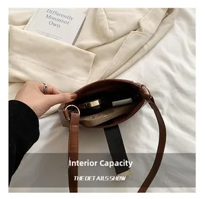 Detailed view of brown leather shoulder bag interior showing storage for phone and makeup