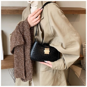 Detail of black crocodile texture shoulder bag with premium gold metal lock buckle