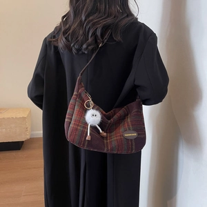 Retro plaid oversized hobo bag with furry charm and leather strap on black coat