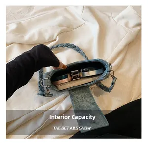 Detail view of denim shoulder bag interior capacity showing phone and makeup items