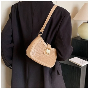 Detail of khaki woven shoulder bag featuring a gold metal clasp and premium leather texture