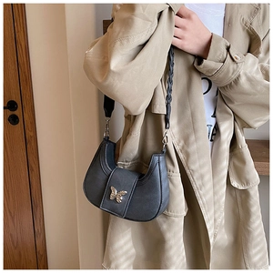 Detail of dark grey hobo bag featuring a silver butterfly buckle and dual shoulder straps