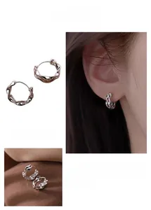 Detail of silver double-layered Mobius hoop earrings with a polished twist design