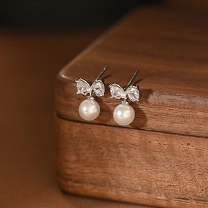 Elegant silver bow earrings with sparkling cubic zirconia and round white pearls