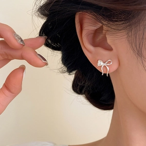 Elegant silver bow earrings with a heart-shaped pearl and asymmetrical ribbon design