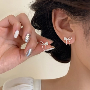 Elegant silver bow stud earrings with white pearl center for a minimalist style