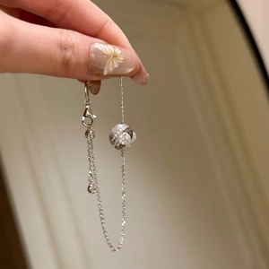 Makroansicht des silbernen Kugelanhängers mit glitzernden Diamanten an einer feinen Kette