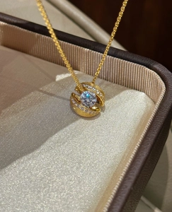 Makroaufnahme von Gold-Hohlkugel-Anhänger mit Mikro-Pavé-Diamanten auf Seide