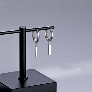 Minimalist silver hoop earrings with polished rectangular bar pendants on a T-stand