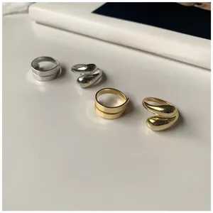Dettaglio di anelli minimalisti in argento S925 e fedi aperte a goccia in oro e argento