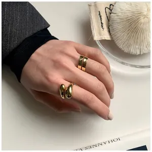 Dettaglio di anelli a spirale dorati e stile liquido in argento su dita femminili