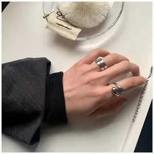Dettaglio del set di anelli in argento S925 con design a spirale e fascia larga moderna
