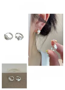 Detailed view of silver star hoop earrings featuring a brushed finish and small side crystals