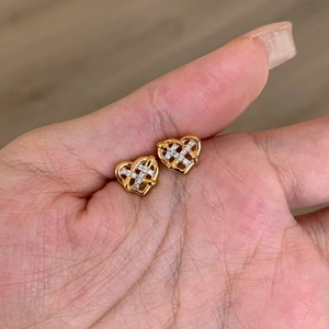 Exquisite hollow heart stud earrings in gold with criss-cross zircon crystals in hand