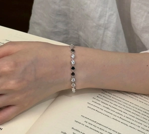 Close-up of vintage silver bracelet with round zircons on an open book background