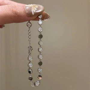 Vintage style silver bracelet with round zircons and polished discs on warm background