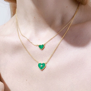 Elegant gold double-layered necklace featuring green malachite heart-shaped pendants