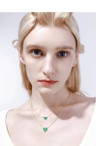 Detail of layered S925 silver heart necklaces with green malachite and star motif