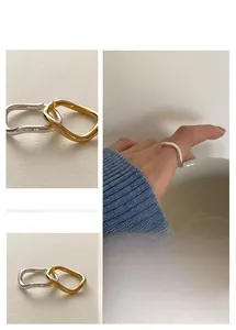 Detailed view of minimalist wave rings in gold and silver finish worn on fingers
