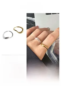 Detailed view of gold and silver S925 sterling silver wavy rings with irregular design