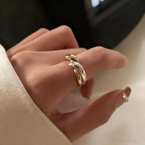 Chic two-tone twisted wave ring in gold and silver finish for a modern minimalist style