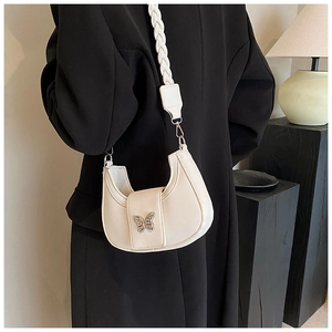Detail of off-white leather crescent bag with silver butterfly buckle and braided strap