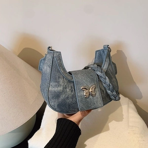 Blue denim hobo underarm bag with silver butterfly buckle and braided strap detail