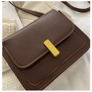 Détail du petit sac vintage marron foncé avec son fermoir en métal doré et texture cuir
