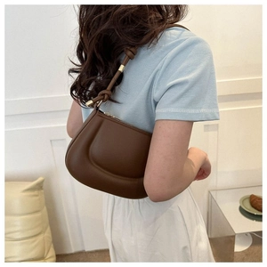 Detail of chocolate brown shoulder bag with knotted strap and soft padded texture