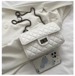 White quilted chain bag detail showing interior capacity next to a smartphone