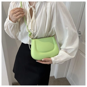Detail of lime green padded saddle bag with metal hardware shown on a model