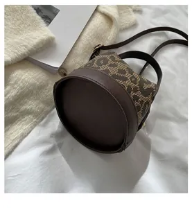 Detail shot of the round leopard print fabric base and brown pebble leather trim