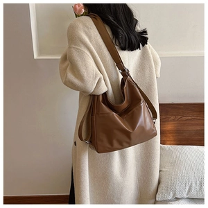 Vue latérale du sac fourre-tout en cuir PU marron avec sangle réglable et poche latérale