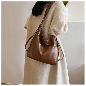 Détail de la boucle argentée ajustable sur le sac hobo en cuir PU marron avec poche latérale