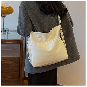 Détail du sac fourre-tout en cuir PU crème avec bandoulière large et poches avant
