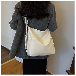 Détail du sac cabas en similicuir crème montrant la texture souple et la bandoulière large