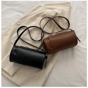 Detailed top view of vintage cylindrical leather crossbody bags in black and brown